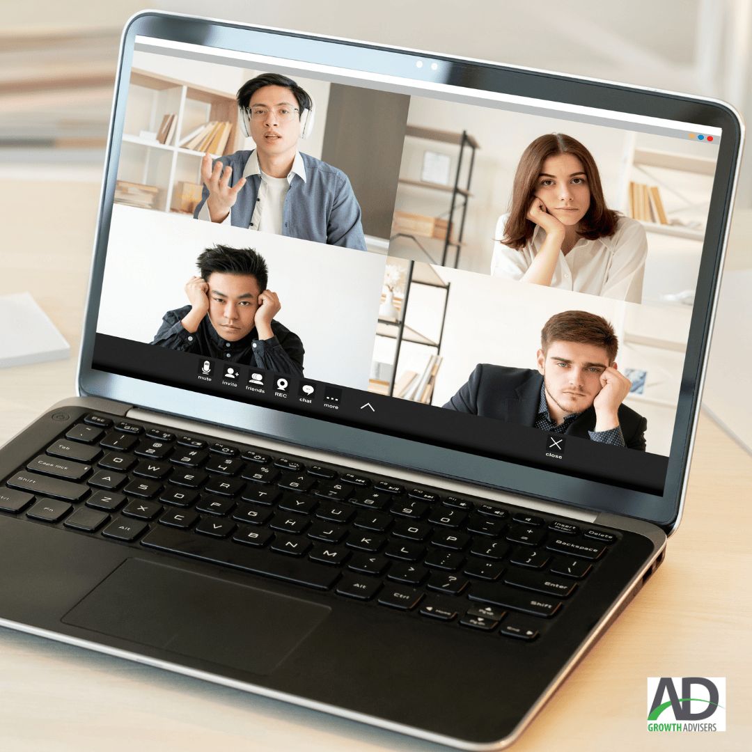 Four people on a video call on a laptop, three looking disengaged